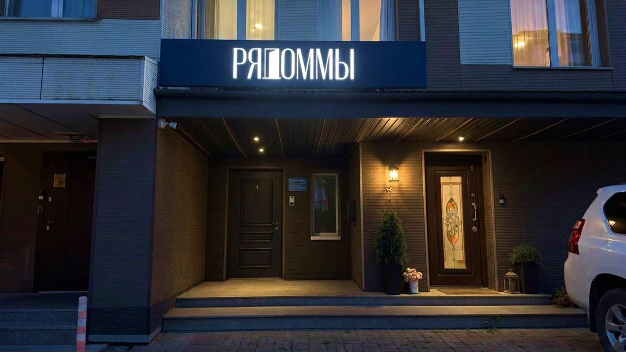 вывеска РяДом.МЫ на фасаде офиса вечером, световой короб с объёмным логотипом